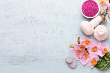 Spa aromaterapi arka planı, basit orkide çiçekleriyle süslenmiş çeşitli güzellik ürünleri..