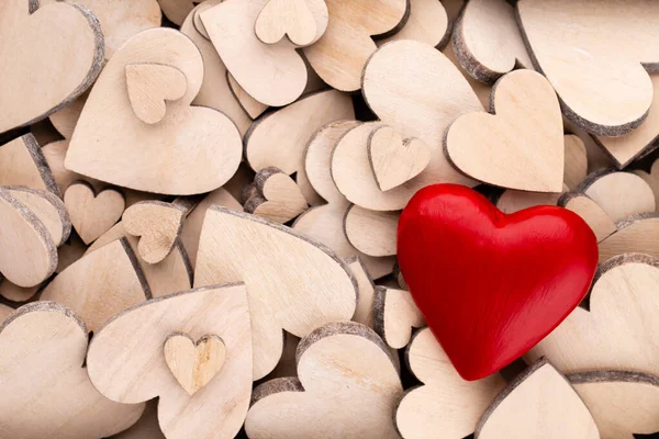 Wooden hearts pattern, one red heart on the wooden heart background.