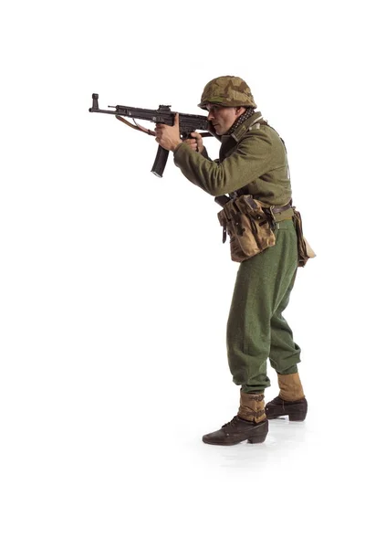 Man actor in the movie role of an old military man  with a MG 42 machine gun posing against white background