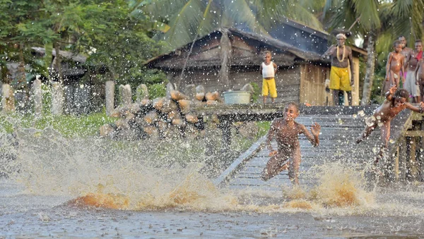 Tribù di persone Asmat fare il bagno e nuotare — Foto Stock