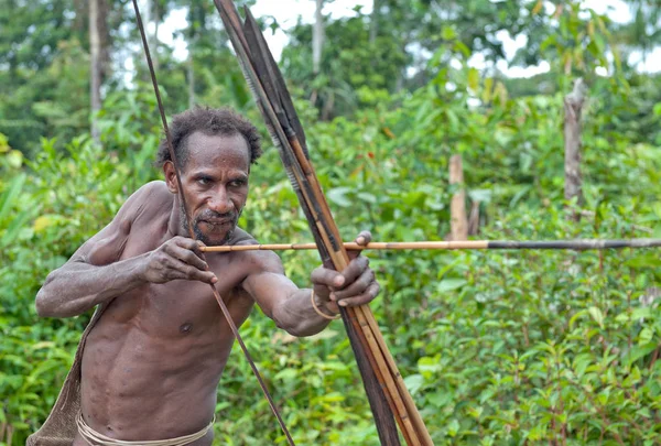 Adam Korowai kabile bir yay vuruyor — Stok fotoğraf