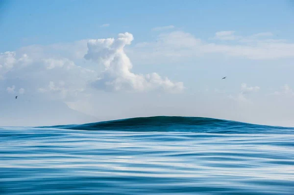 Clouds sky, waves with splashes — Stock Photo, Image