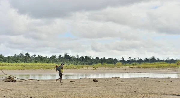 Mulher da tribo Korowai com bebê — Fotografia de Stock