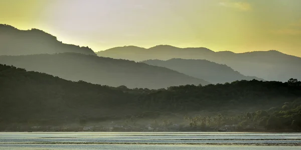 Сумерки перед восходом солнца на побережье океана. Океан и горы — стоковое фото