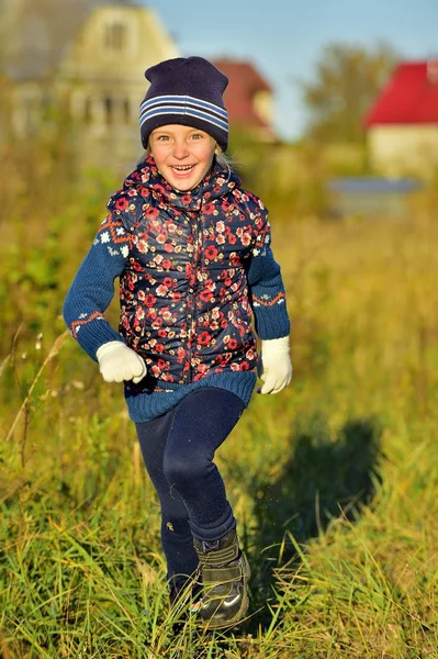 Смеющаяся маленькая девочка, бегущая под солнцем — стоковое фото
