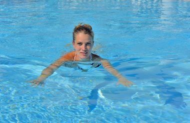 Kız yüzme havuzunda. Yüzme Havuzu, güzel ve genç birbayan. Mavi su arka plan.