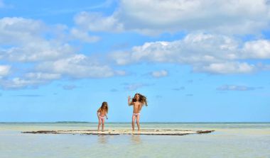 Gün batımı ışık kum plajındaki sevimli küçük kız. Küba. Caya Coco.