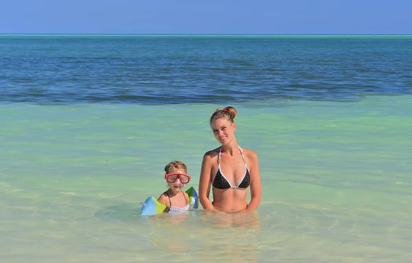 夏休みだ 母とかわいい娘が青い海で遊んだり泳いだりします キューバだ — ストック写真