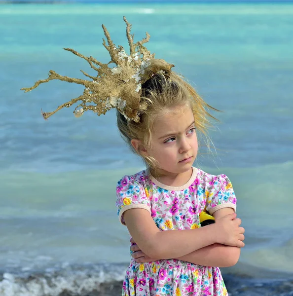 青い海を背景に彼女の頭の上のサンゴ クラウンと少女の肖像画 — ストック写真