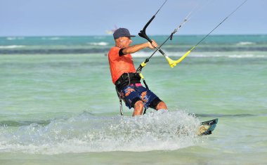 Cayo Guillermo, Cuba - December 17 2017: Man riding his kiteboard on Cayo Guillermo in Atlantic Ocean, Enjoy kite surfing. December 2017 in Cuba. Caya Guillermo is a popular beach for kitesurfing. clipart