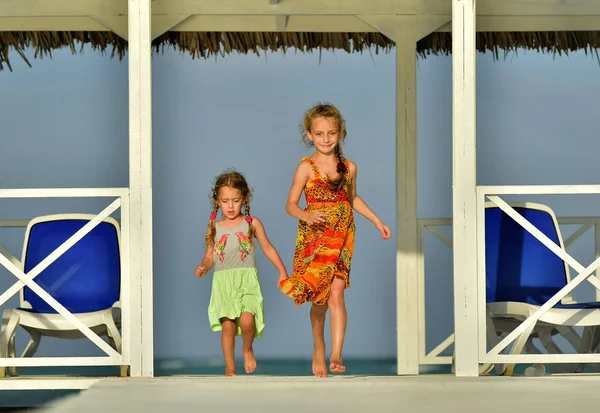 小女孩穿着五颜六色的衣服在白色的木码头靠近海边 Caya 可可海滩季节 — 图库照片