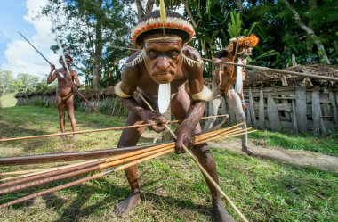 Dani Köyü, Wamena, Irian Jaya, Yeni Gine, Endonezya - Haziran 4: Silahlı Papua attakking. Dani Dugum kabilesinin savaşçı. 4 Haziran 2016, Yeni Gine Adası.