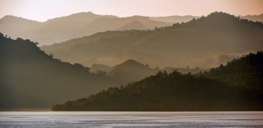 Alacakaranlık okyanus kıyısında güneş doğmadan önce. Okyanus ve dağ sisli sabahı manzara. Komodo Adası. Moluccas, Endonezya Maluku, Baharat Adaları, Endonezya Adaları, Malay Takımadaları.