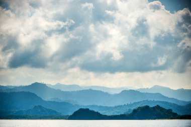 Alacakaranlık okyanus kıyısında güneş doğmadan önce. Okyanus ve dağ sisli sabahı manzara. Komodo Adası. Moluccas, Endonezya Maluku, Baharat Adaları, Endonezya Adaları, Malay Takımadaları.