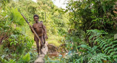 Vahşi ormanda Yeni Gine Adası, Endonezya - 24 Haziran: Papuans Korowai (Kolufo) kabilesinden ok ve yayla vahşi ormanlarda, Yeni Gine. 24 Haziran 2016, Yeni Gine, Endonezya