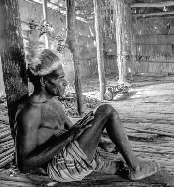 Youw Köyü, Atsy bölgesi, Asmat bölgesi, Irian Jaya, Yeni Gine, Endonezya - 23 Mayıs 2016: Erkekler evde davul insanlarla Asmat kabilesi bir adam portresi. Asmat karşılama töreni.