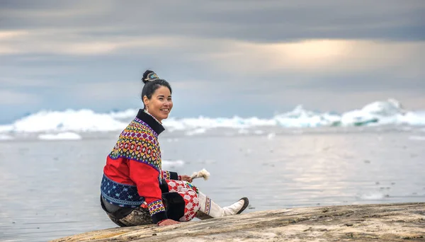 2018年7月11日 グリーンランドの小さな村の近くの海の海岸で写真を撮るためにポーズをとっている伝統的な服を着た若いイヌイットの女性 — ストック写真