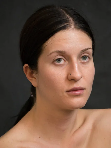 Portrait of Young Woman With Dark Hair Against Dark Background