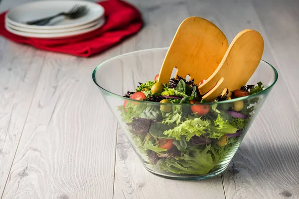 Zielona sałata w szklanej misce na stole — Zdjęcie stockowe