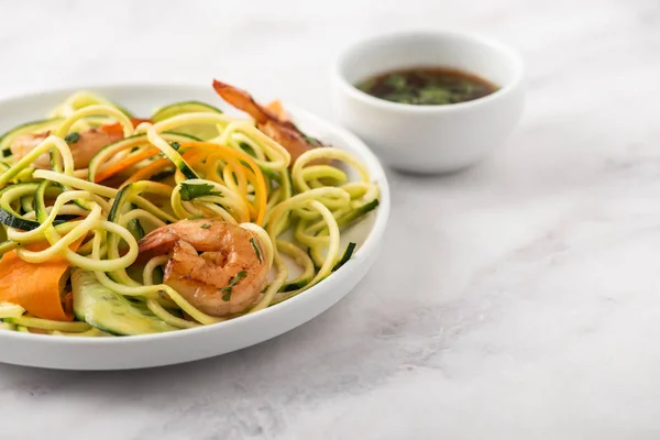 Zucchini salad with prawns flatlay on a marble countertop