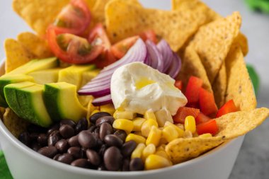 Karabiberli Meksika cipsi. Domates, mısır, avokado ve krema.