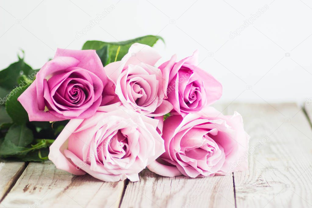 Blurred pink roses on wooden background