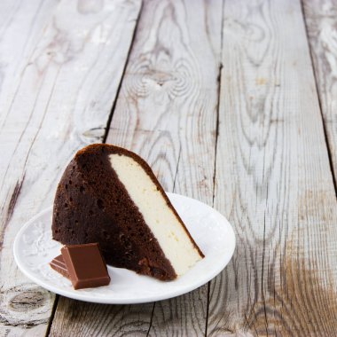 Çikolata-süzme peynir pasta ve ahşap arka plan üzerinde süt.