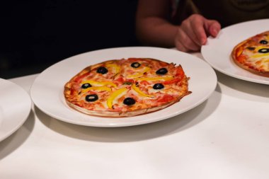 Yuvarlak pizza beyaz masa bölümü.