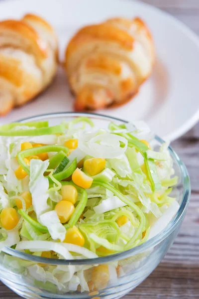 Salada com croissant em fundo de madeira . — Fotografia de Stock