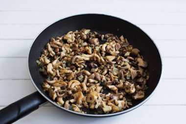 Kızarmış istiridye mantar soğan pan seçici odak doğranmış.