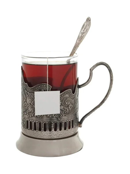 Vaso con té y una cucharadita en un sostenedor de la taza aislado en un whit —  Fotos de Stock