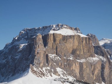 Rocks lit by the rising sun against a blue cloudless sky.