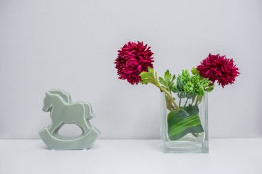 Güzel yıldız çiçeği çiçek ve seramik at çim üzerinde ışık bac içinde
