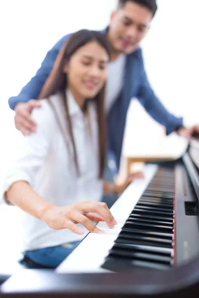 Mari enseignant à sa femme à jouer du piano — Photo