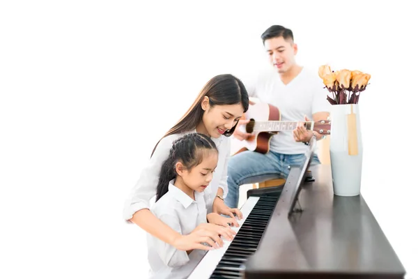 Famille asiatique, mère et fille jouant du piano, père jouant — Photo