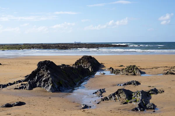 Hermosas olas rompen en las rocas negras — Foto de Stock