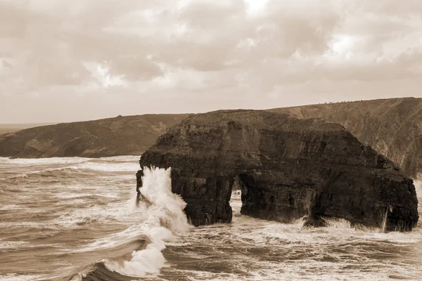 Сепия девственная скалы с бурными волнами — стоковое фото