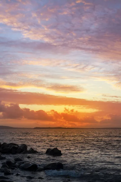 Tramonto e acqua calma sulla spiaggia di beal — Foto Stock