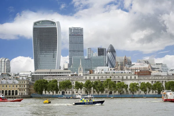 ロンドン市内の高層ビルを背景に川沿いの警察船が — ストック写真