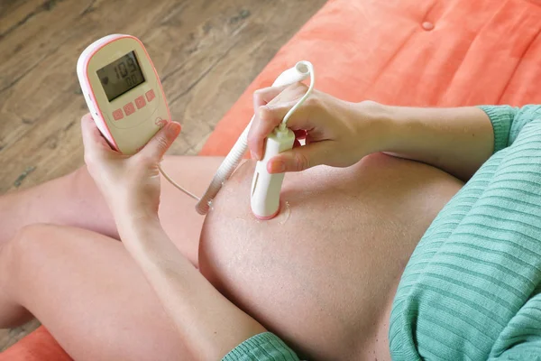 Pregnant woman with a fetal doppler — Stock Photo, Image