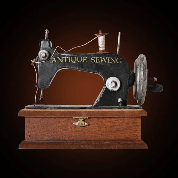 Máquina de costura antiga no fundo marrom escuro — Fotografia de Stock