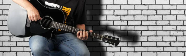 Music - Fragment man play a black acoustic guitar — Stock Photo, Image