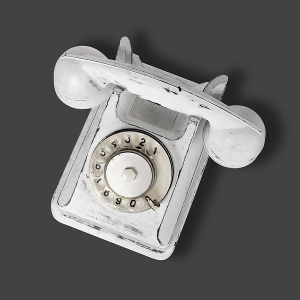 Descasque o telefone vintage branco em um fundo cinza escuro — Fotografia de Stock