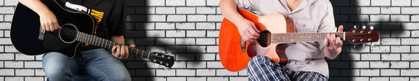 Muziek - Fragment twee man spelen een zwart en oranje akoestische gitaar — Stockfoto
