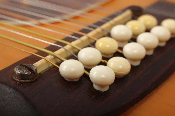 Hudební nástroj - most kolíky dvanáctistrunná akustická kytara — Stock fotografie