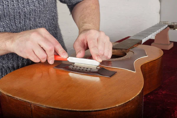 Reparatur und Service von Gitarren - Arbeiter schleifen spezielle Werkzeugbrücken — Stockfoto