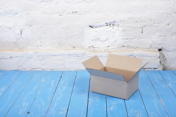 Verzending en verpakking dienst - Open klein pakketje bakstenen muur — Stockfoto