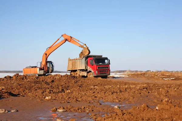 Construcción - Excavadora detrás del trabajo de camión volquete — Foto de Stock