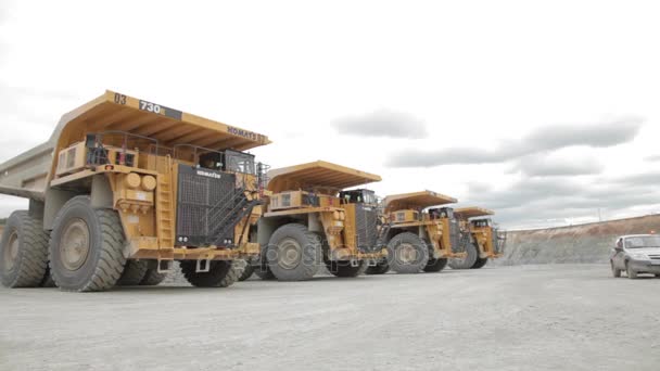 Cuatro camiones volquete pesados y coche de servicio — Vídeos de Stock