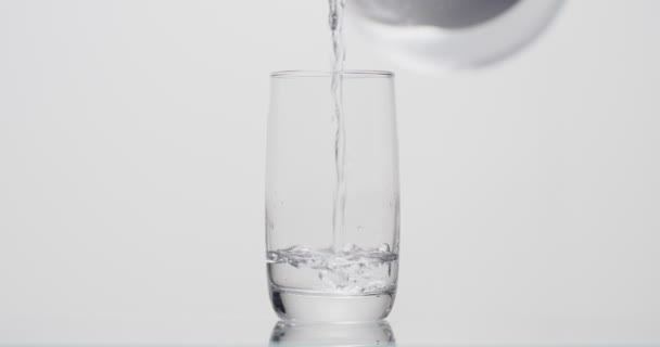 homme verse un verre d'eau sur un fond blanc 